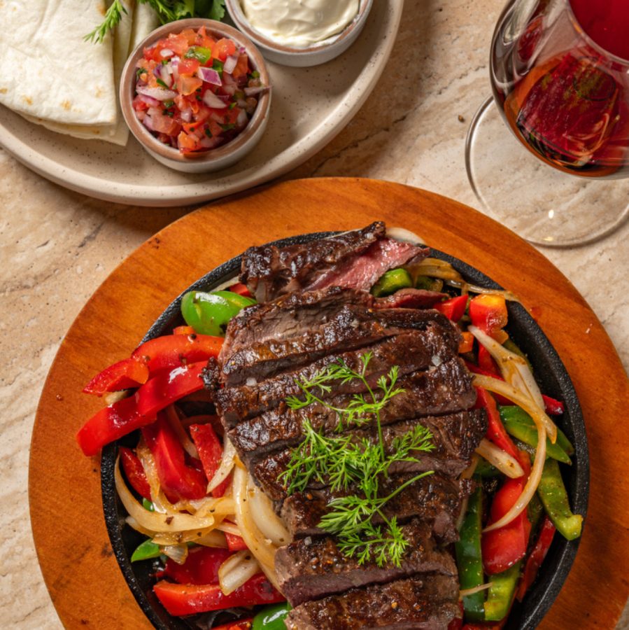 Sizzling steak fajitas with capsicum on a cast iron plate at Angelica Norwest