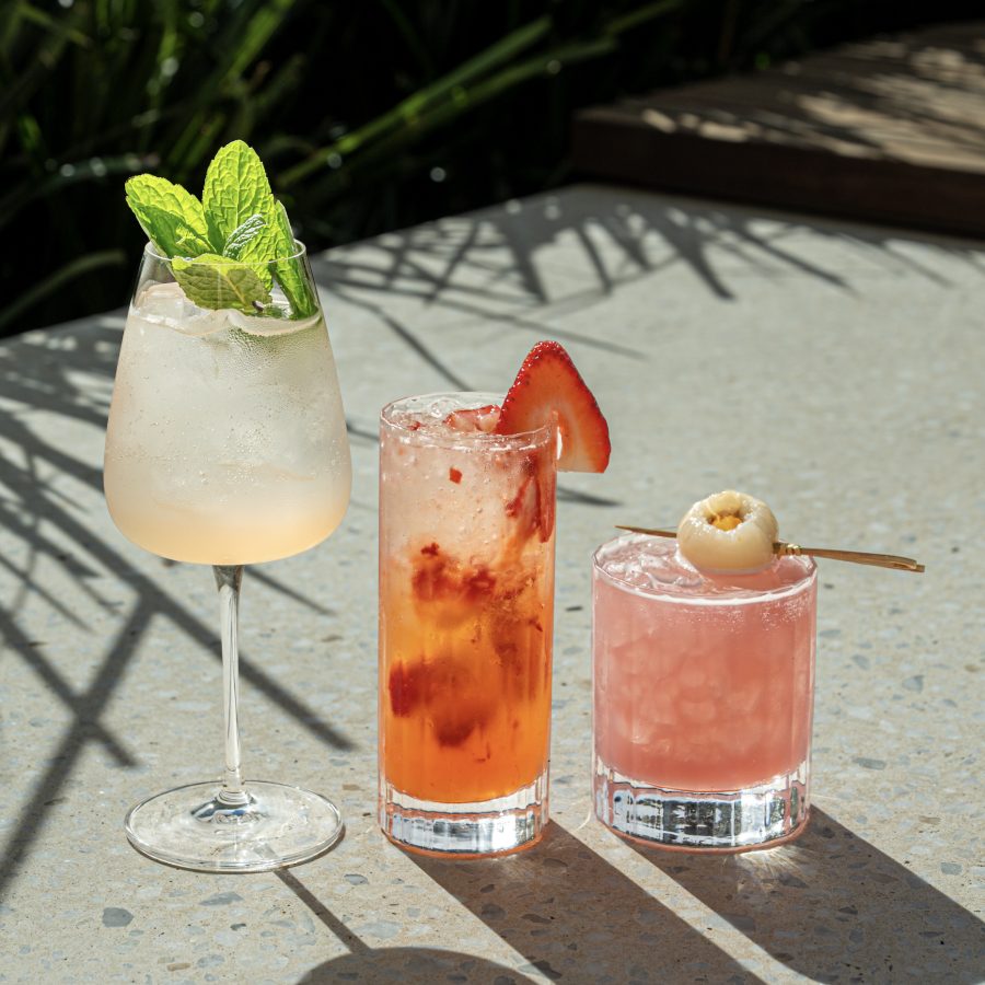 Three cocktails garnished with strawberry and lychee at Angelica Norwest