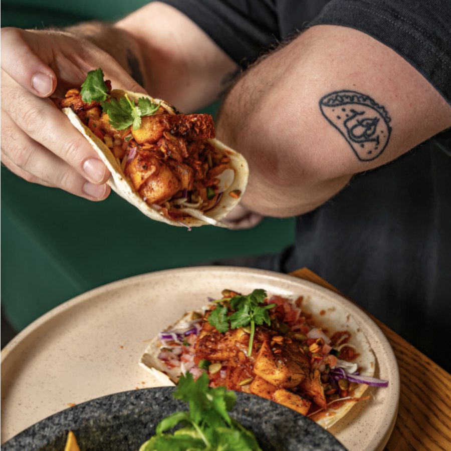 Hand holding a filled bao bun at Angelica Norwest