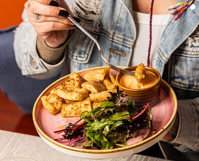 Bowl of crisp fried potatoes with a dipping sauce