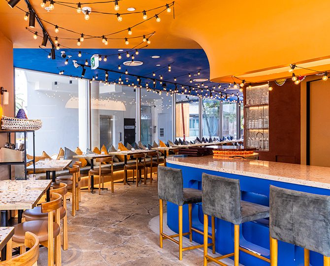 Bright dining room with festoon lights and a blue bar at Baja Cantina Bourke Street