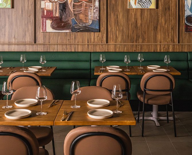 Set tables along a green banquette at Angelica Norwest