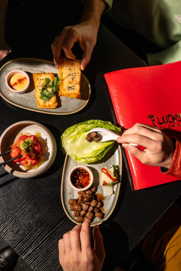 Hand serving a lettuce cup beside the Lucky You Darling sign