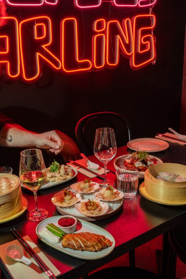 Table set with wine glasses under red light at Lucky You Darling
